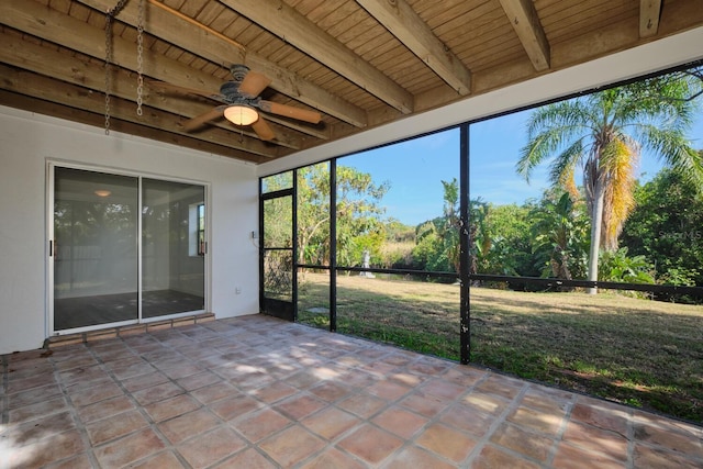 unfurnished sunroom featuring beam ceiling, ceiling fan, and wooden ceiling