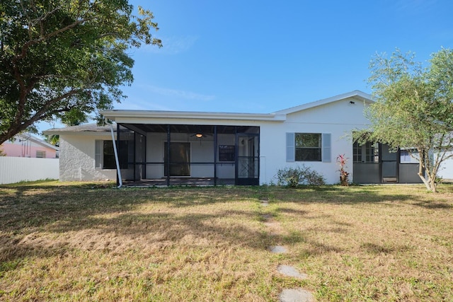 back of property with a yard and a sunroom