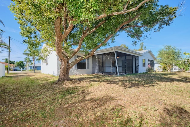 back of house featuring a sunroom and a yard