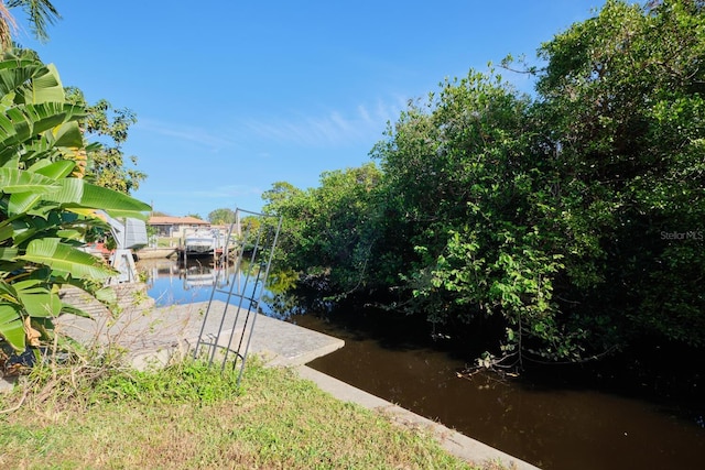 view of yard with a boat dock and a water view