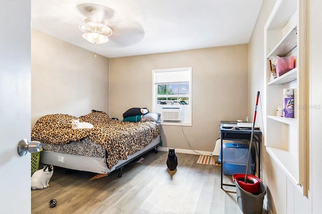 bedroom with hardwood / wood-style flooring, ceiling fan, and cooling unit