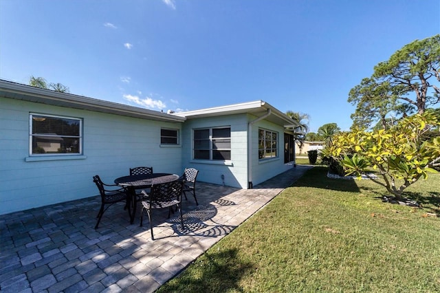 rear view of property with a yard and a patio area