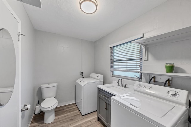 washroom featuring sink, independent washer and dryer, and light wood-type flooring