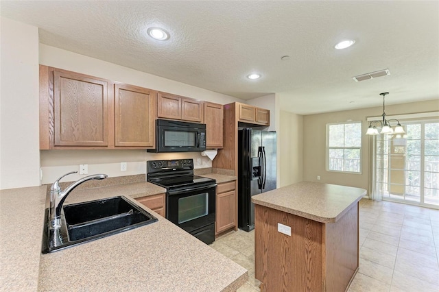 kitchen featuring sink, a chandelier, decorative light fixtures, a kitchen island, and black appliances