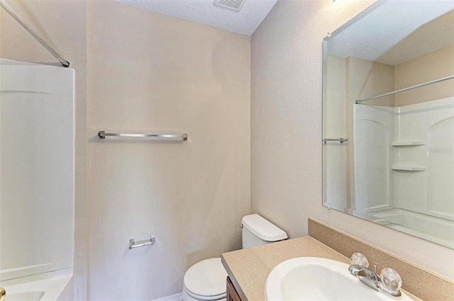 bathroom with vanity, toilet, and a shower