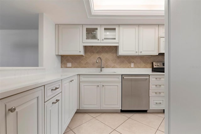 kitchen with white cabinets, light tile patterned floors, stainless steel dishwasher, and sink