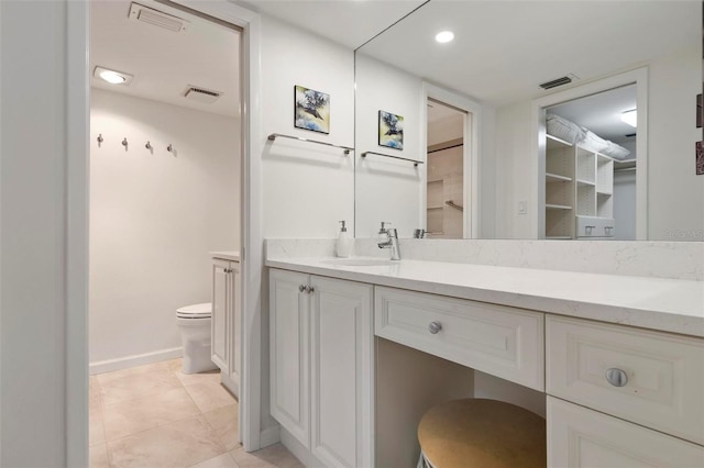 bathroom with tile patterned flooring, vanity, and toilet