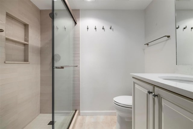 bathroom with vanity, an enclosed shower, and toilet