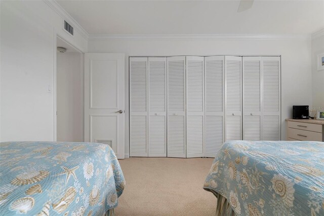 bedroom featuring crown molding, a closet, ceiling fan, and light colored carpet