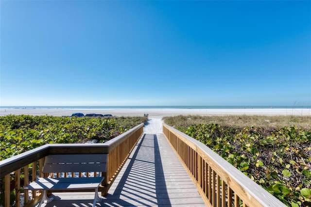 view of property's community with a water view and a view of the beach