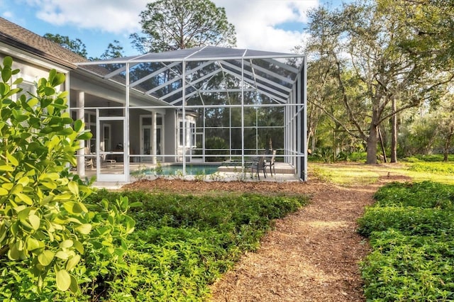 rear view of property featuring glass enclosure