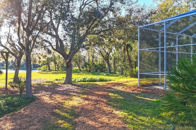 view of yard with glass enclosure and a water view