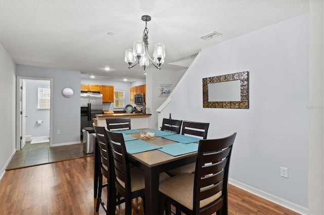 dining room with dark hardwood / wood-style flooring and a chandelier