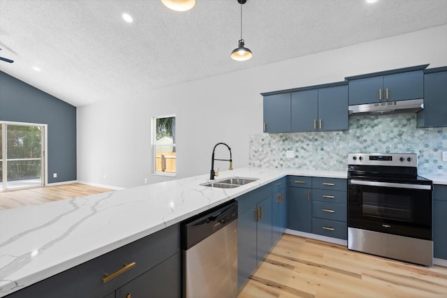 kitchen featuring decorative backsplash, appliances with stainless steel finishes, blue cabinets, sink, and lofted ceiling