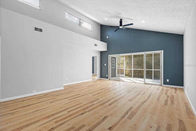 unfurnished living room with plenty of natural light, light hardwood / wood-style floors, a towering ceiling, and ceiling fan