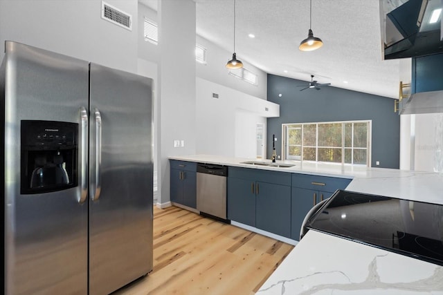 kitchen featuring blue cabinets, hanging light fixtures, sink, a textured ceiling, and appliances with stainless steel finishes