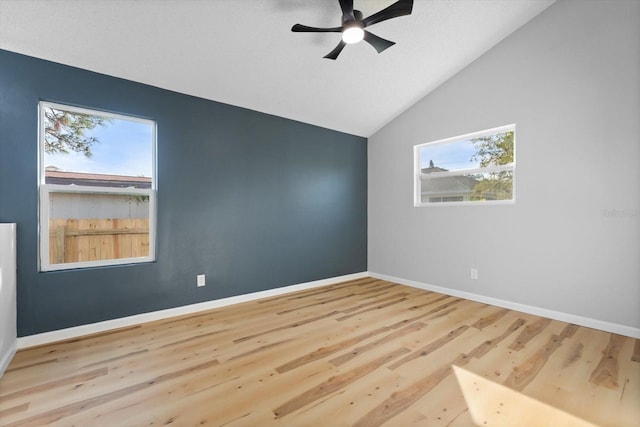 unfurnished room with ceiling fan, light hardwood / wood-style flooring, a healthy amount of sunlight, and vaulted ceiling