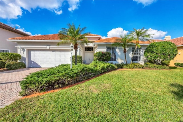 mediterranean / spanish-style home with a front yard and a garage