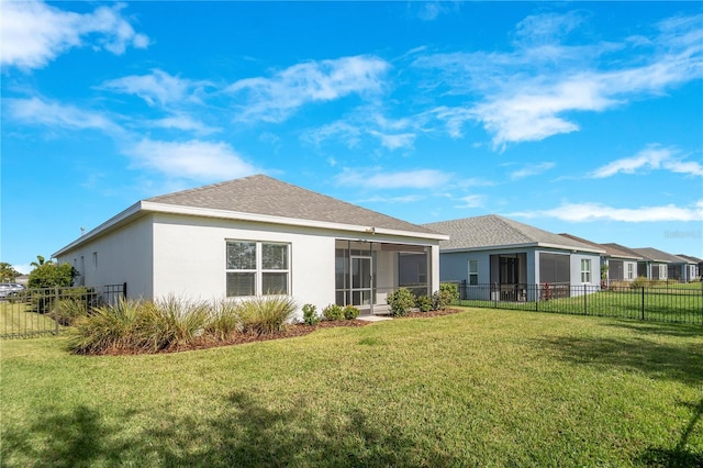 rear view of property featuring a sunroom and a yard