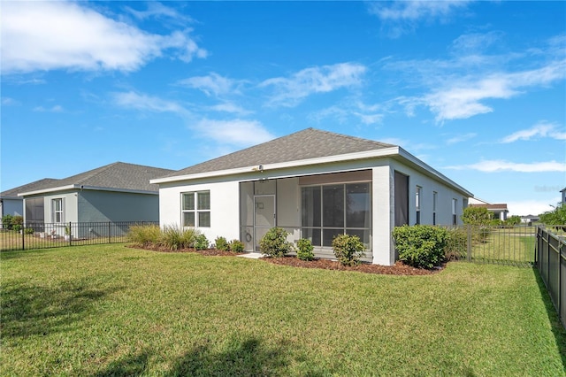 rear view of property with a yard and a sunroom