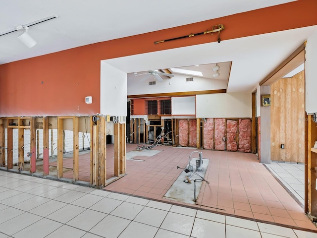 spare room with ceiling fan, vaulted ceiling, light tile patterned flooring, and track lighting