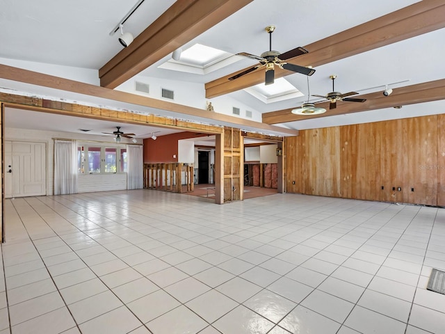 spare room featuring track lighting, wooden walls, vaulted ceiling with beams, ceiling fan, and light tile patterned floors