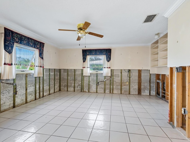 unfurnished room featuring ceiling fan, a wealth of natural light, light tile patterned floors, and ornamental molding