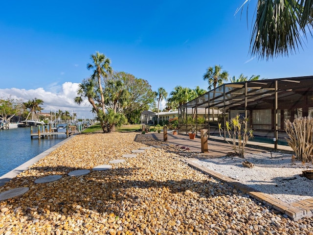 view of yard featuring a water view and glass enclosure