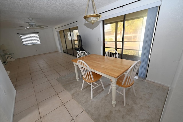 tiled dining area with a textured ceiling and ceiling fan