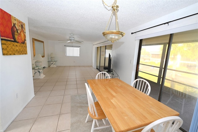 tiled dining space featuring ceiling fan and a textured ceiling