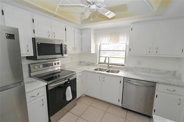 kitchen featuring white cabinetry, sink, light tile patterned floors, and stainless steel appliances