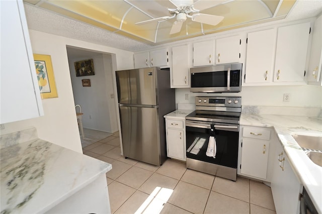 kitchen with white cabinetry, light tile patterned floors, stainless steel appliances, and ceiling fan