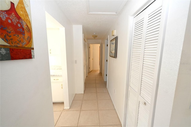 hall with light tile patterned floors and a textured ceiling