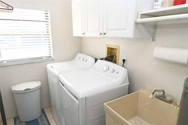 washroom with tile patterned floors, washing machine and dryer, sink, and cabinets