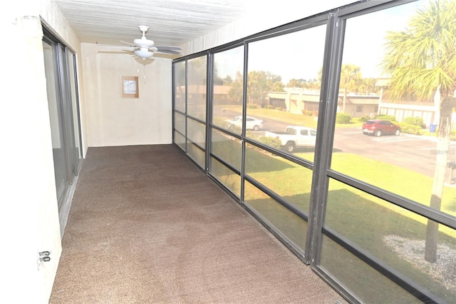 unfurnished sunroom featuring ceiling fan