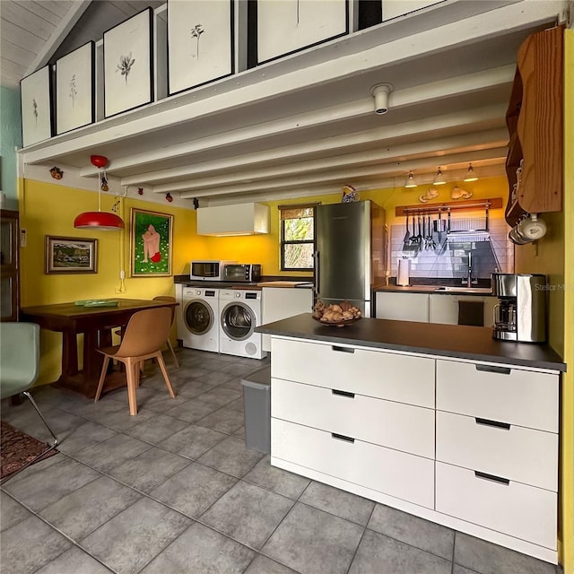 laundry room featuring light tile patterned floors, sink, and washing machine and clothes dryer