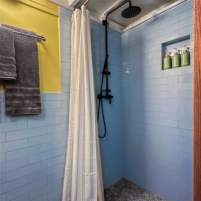 bathroom with a shower with shower curtain and tile walls