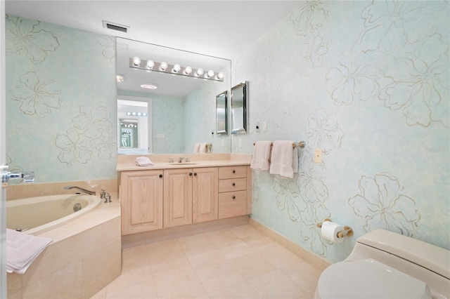 bathroom featuring tile patterned floors, vanity, toilet, and tiled tub