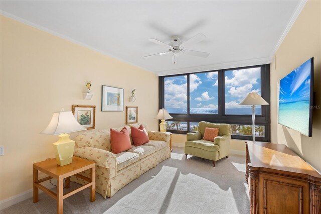 living room with ceiling fan, light colored carpet, ornamental molding, and a wealth of natural light