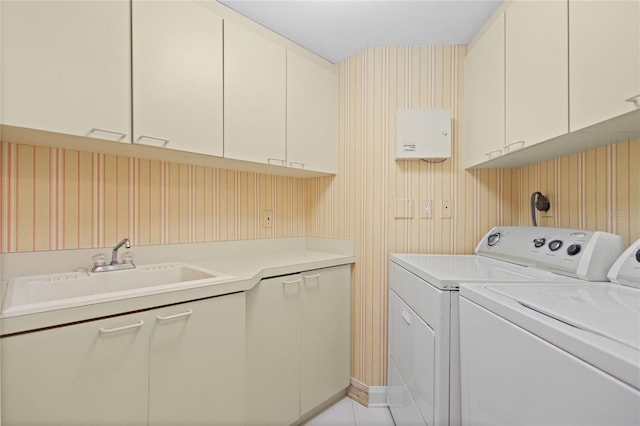 laundry room featuring separate washer and dryer, sink, and cabinets