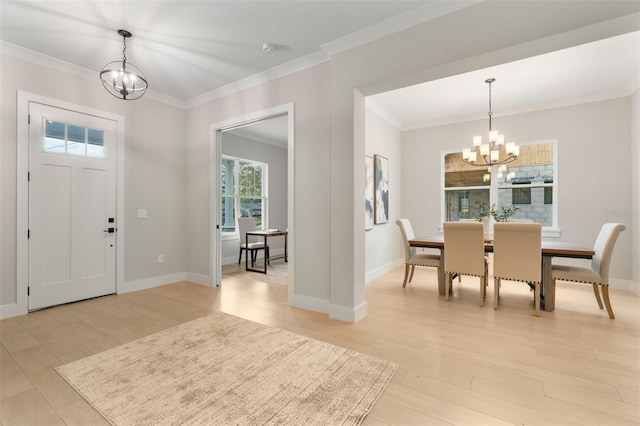 entryway with light wood-style floors, crown molding, baseboards, and an inviting chandelier