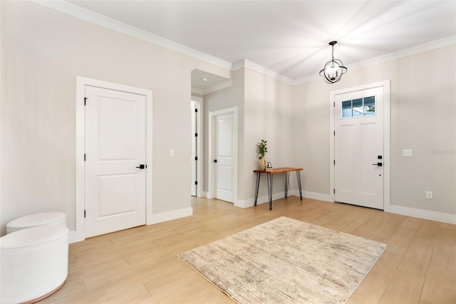 foyer entrance with ornamental molding, light wood finished floors, and baseboards