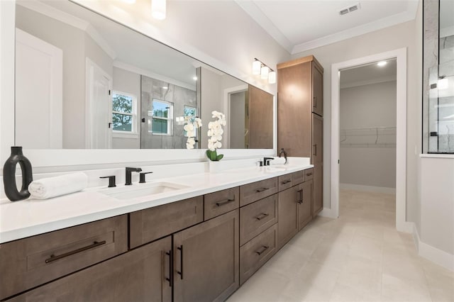 full bathroom featuring double vanity, visible vents, ornamental molding, a walk in closet, and a sink