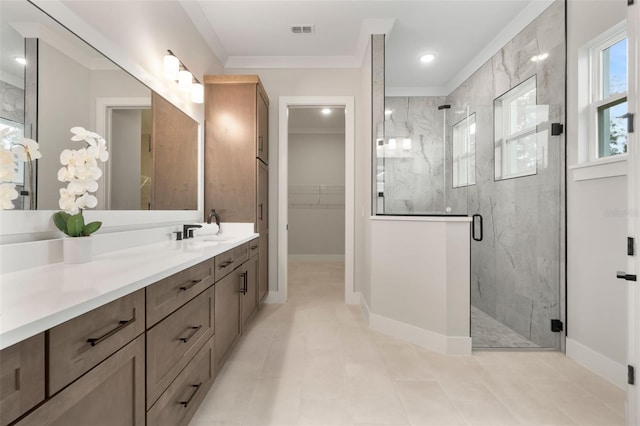 bathroom featuring a walk in closet, a marble finish shower, visible vents, vanity, and baseboards