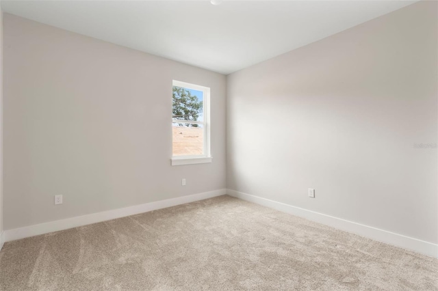 carpeted spare room with baseboards