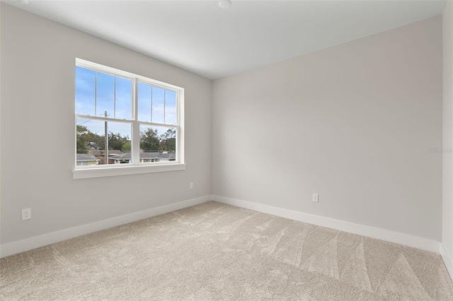 unfurnished room with light carpet and baseboards