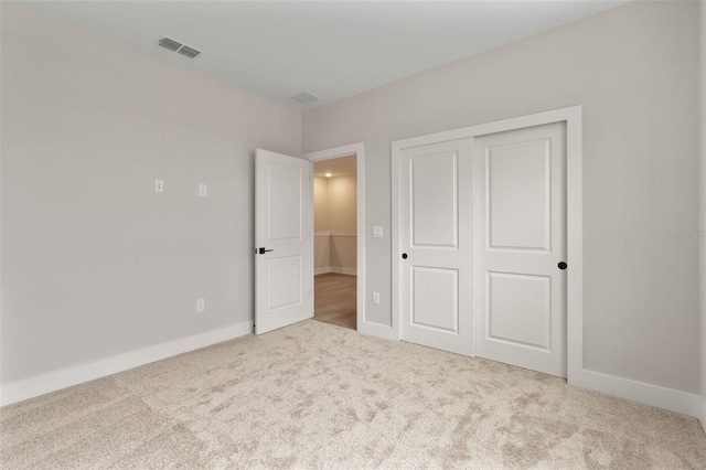 unfurnished bedroom with carpet, a closet, visible vents, and baseboards