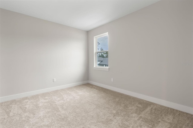 empty room featuring carpet floors and baseboards