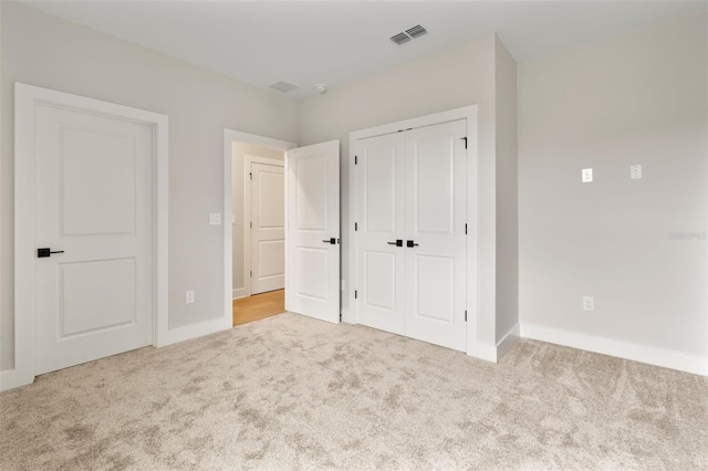 unfurnished bedroom with a closet, carpet flooring, visible vents, and baseboards