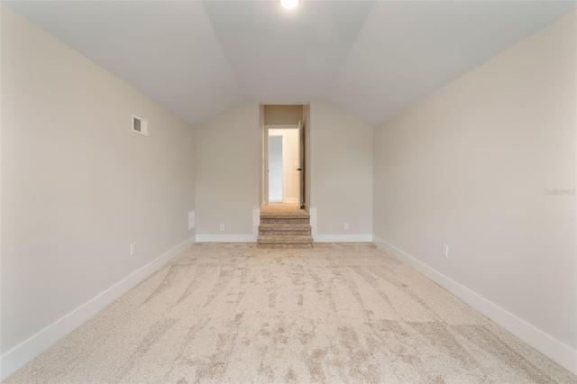 bonus room featuring lofted ceiling, visible vents, light carpet, and baseboards